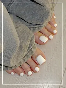Detailed view of glossy white square wearable toe nail patches for women in lifestyle setting
