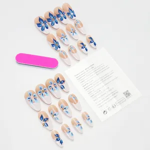 Flat lay of press-on nails set with blue floral art, mini file and adhesive stickers