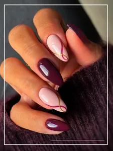 Detail of almond-shaped press-on nails in deep plum and gold wavy line art