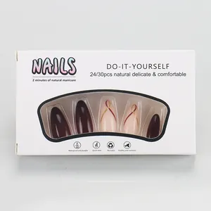 Detail view of almond press-on nail set in deep burgundy and gold striping in box