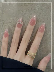 Detailed view of nude pink cat-eye press-on nails with silver glitter and rhinestone accents
