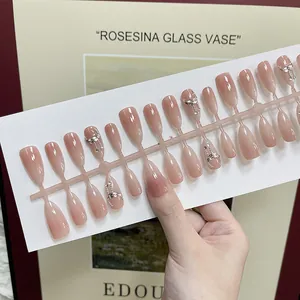 Handmade nude pink cat-eye press-on nails with silver rhinestone bow and gradient finish