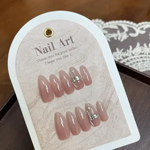 Handmade almond press-on nails in nude pink cat-eye finish with rhinestones and silver chains