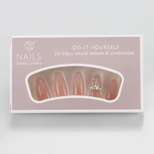 Detailed view of handmade nude pink cat-eye press-on nails with rhinestones and chain