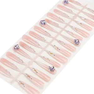 Faux ongles longs coffin rose clair avec cristaux violets et strass scintillants