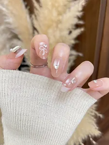 Nahaufnahme rosa ovaler Kunstnägel mit weißen Schmetterlingsschleifen und Perlen
