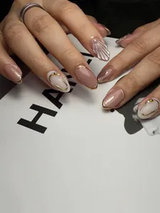 Macro detail of shell texture cat eye nails with pearl accents and golden edges