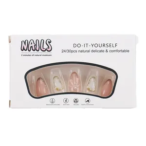 Pale pink and white press-on nail set with 3D pearls and gold details in packaging