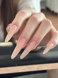Macro detail of long almond-shaped nails with nude pink gradient and high gloss finish