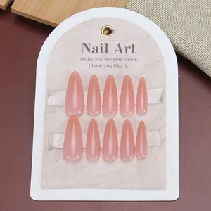 Long almond-shaped gradient nude pink press-on nails set on a white display card