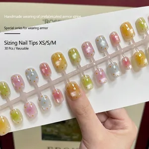 Short square press-on nails with cat-eye effect and orange dots in macaron colors