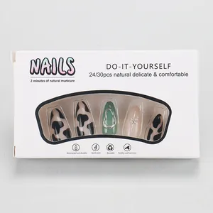 Detailed press-on nail kit featuring cow print and metallic star patterns in a white box