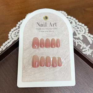 Close-up of glossy pink gradient long round press-on nails set on a display card