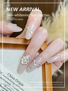Close-up of pink press-on nails featuring luxury crystals and heart-shaped rhinestones