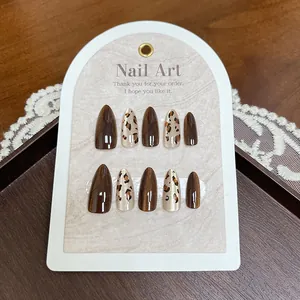Caramelbruine cat-eye kunstnagels in amandelvorm met trendy luipaardmotieven