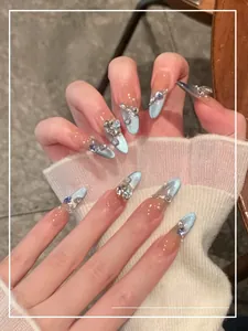Macro shot of light blue cat eye stiletto press-on nails with luxury rhinestones and pearls