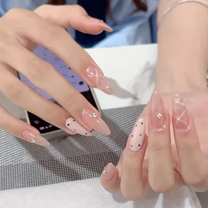 Elegant nude pink press-on nails with polka dots, geometric lines and small rhinestones
