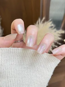 Vue détaillée des faux ongles œil de chat nude avec un fini nacré scintillant