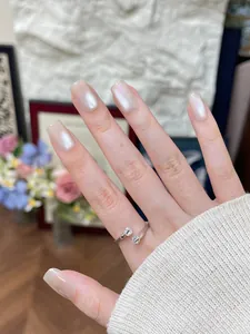 Gros plan d'une bague ajustable en argent avec doubles zircons et manucure élégante