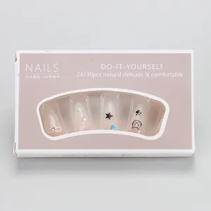 Detail view of handmade pink gradient press-on nails with bow and cat motifs in a box
