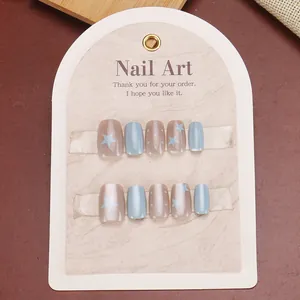 Short press-on nails set with blue and brown star patterns on Nail Art display card