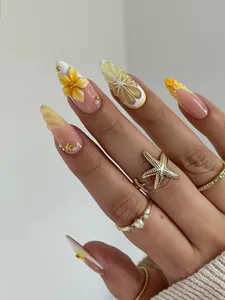 Detail of 3D embossed flowers and lemon patterns on handmade almond press-on nails