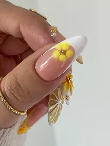 Macro view of long almond press-on nails with 3D floral accents and lemon patterns