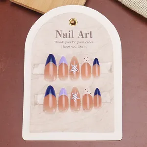 Long almond press-on nails with French tips, blue stars, and red polka dot patterns