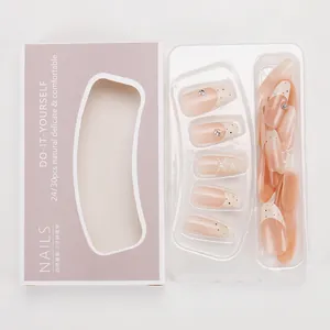 Detail of nude almond press-on nails set with white polka dots and rhinestones