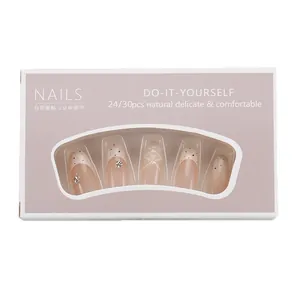 Elegant nude almond press-on nails set with black polka dots and pearls in window box