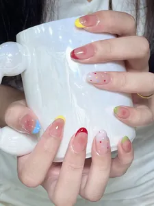 Détail de faux ongles French colorés avec des pois ludiques et une finition brillante