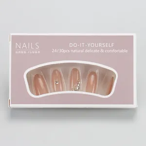 Macro view of nude blush press-on nails set with rhinestones in window gift box