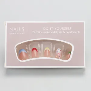 Vue détaillée de faux ongles à pointes françaises colorées et à pois en boîte