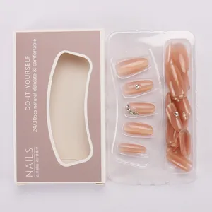 Close-up of nude press-on nail set with rhinestones and glitters in packaging
