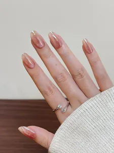 Dettaglio anello argento con doppi strass su unghie rosa effetto occhio di gatto