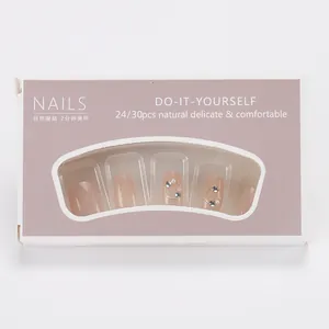 Detailed view of nude pink press-on nails with fine glitter, rhinestones, and pearls