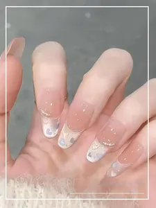 Detail of pink gradient press-on nails with heart patterns and shimmering glitter accents