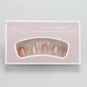 Macro shot of nude pink gradient press-on nails with bow designs and polka dots