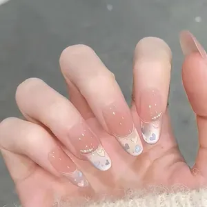 Long almond press-on nails with nude gradient, colorful hearts, and glitter sparkles