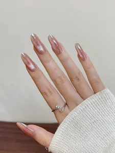 Close-up of long oval aurora pink press-on nails and a silver zircon open ring
