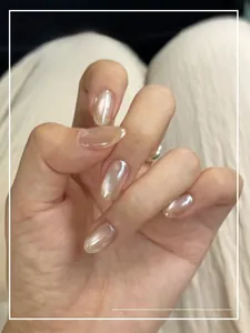 Close-up of translucent pearl white cat-eye press-on nails with soft shimmer