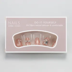 Gros plan d'ongles press-on rose nude œil de chat avec nœuds 3D, perles et cristaux