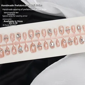 Détail de faux ongles œil de chat rose nude avec nœud argenté et strass brillants