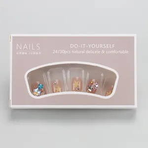 Detail of short almond press-on nails featuring star patterns and colorful rhinestones