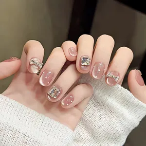 Pink cat-eye press-on nails featuring silver 3D bows and sparkling square rhinestones