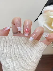 Nahaufnahme von rosa Blush-Farbverlauf-Nägeln mit French Tips und Strass-Akzenten