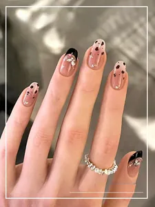 Detail of handmade leopard print and butterfly charm press-on nails for autumn style