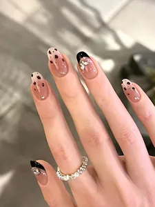 Detail of leopard print press-on nails with silver butterfly charms and french tips