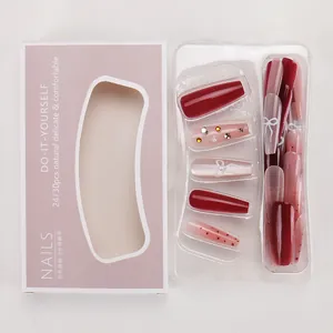 Detailopname van Franse nepnagels in rood-roze verloop met strikje en strass-steentjes
