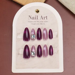 Almond purple cat eye press-on nails with pink glitter and large gemstone accents